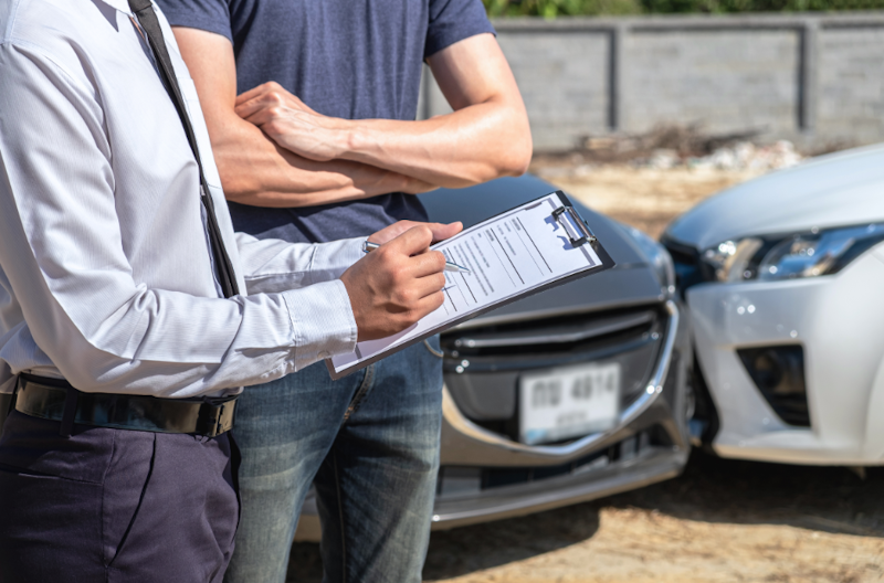 Car Accident Lawyer and a man standing near a damaged car